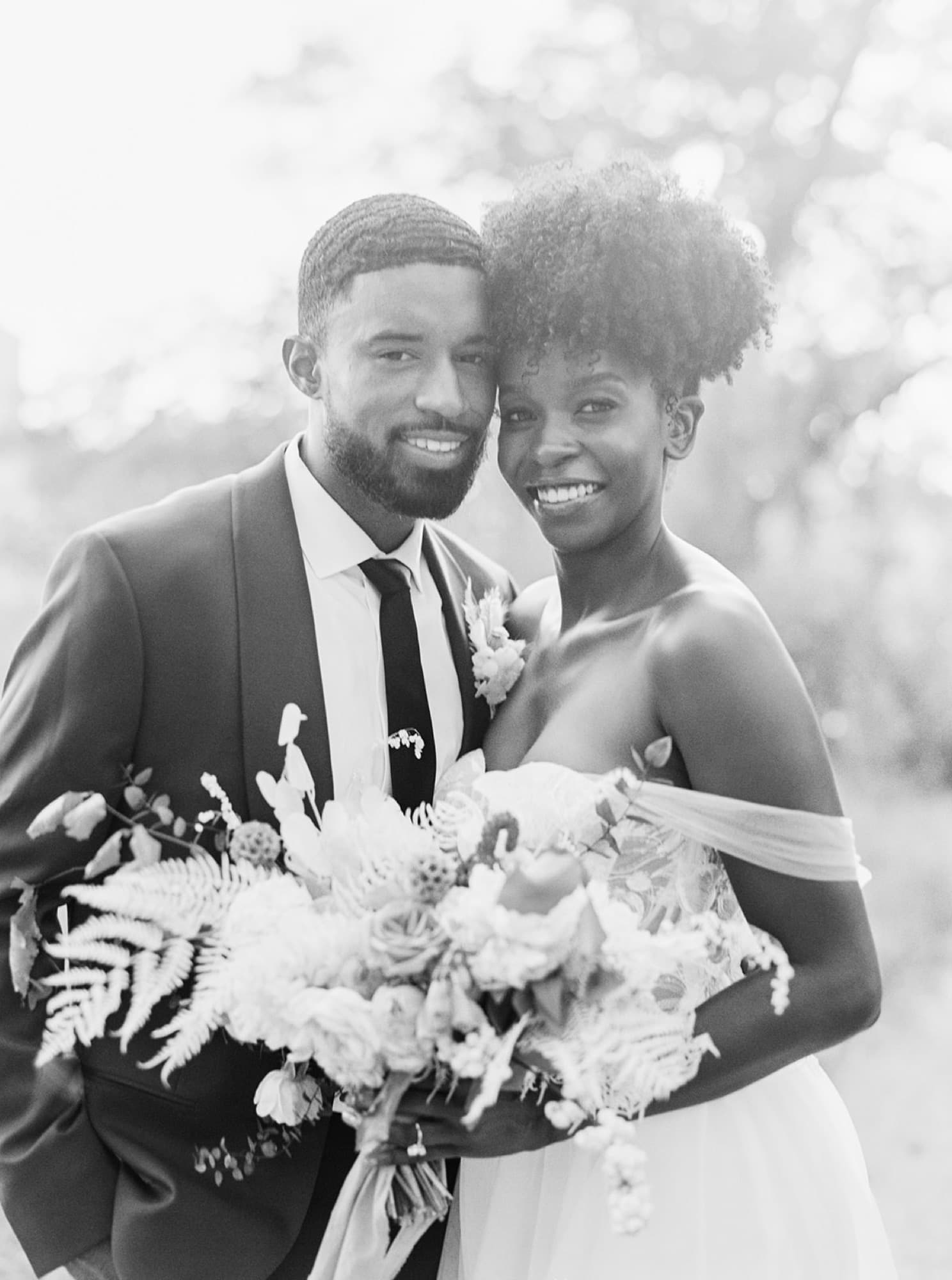 Black and white portrait of Abyon Ausar with a bride holding a bouquet