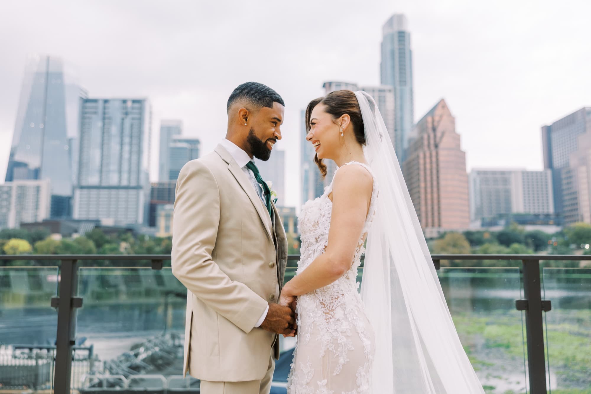 Abyon Ausar in a cream suit with a bride, Austin skyline behind them in daylight