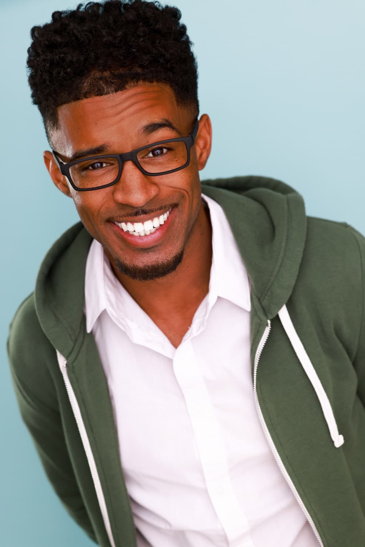 Smiling headshot of Abyon Ausar in a green hoodie and glasses
