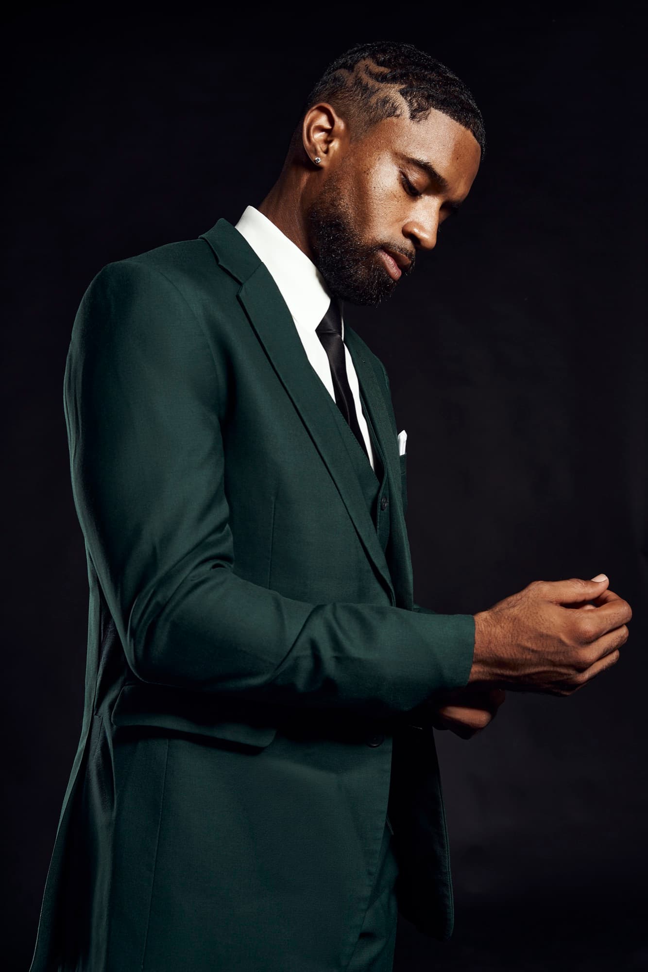 Abyon Ausar in a dark green three-piece suit